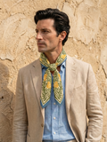 Botanical print scarf in cream, forest green, and mustard yellow. Symmetrical floral design with blue frame border, modern artistic style.